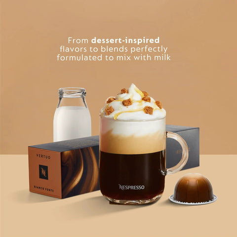 Glass of creamy milk coffee with Vertuo capsule and box next to a bottle of milk on a tan background, focusing on dessert-inspired flavors.
