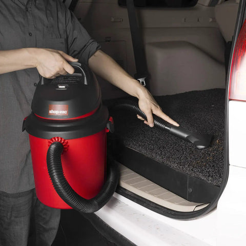 Person using 4 Gallon 4.0 Peak HP Wet Dry Shop Vacuum Grab-and-Go Portable with Wall Mount in car trunk cleanup