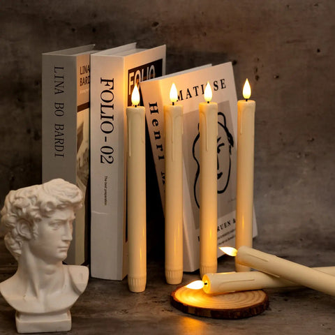 Flameless Taper Candles With Remote Timer And Dimmer Ivory Battery Operated Candle Sticks With Flickering Plastic Led Light For Window Decor 9.6 Inches Dope Halloween And Christmas displayed on a shelf with books and a bust sculpture.