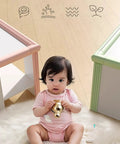 Baby near furniture with Edge Corner Protector Self Adhesive Foam Bumper Guard for furniture visible, pink and green colors