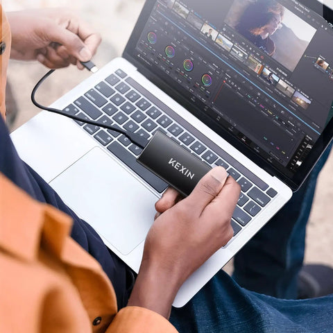Person using 256GB USB 3.1 Type C External SSD Drive Portable Solid State Storage Up To 500MB Per Second For PC Mac Android Game Console And More Ideal For Photo Video Backup And On The Go connected to a laptop
