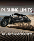 ATV driving through sand dunes with text 'Pushing Limits Polaris Engineered Parts'