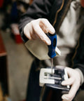 GLOVEWORKS HD ivory latex disposable gloves, large, powder-free, worn while using a blue-handled screwdriver on equipment