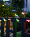 16 Pack Solar Deck Lights Outdoor Color Changing LED Waterproof Pathway Lights For Stairs Patio Yard Garden Fence Porch Decor With Romantic RGB Glow installed on a fence.