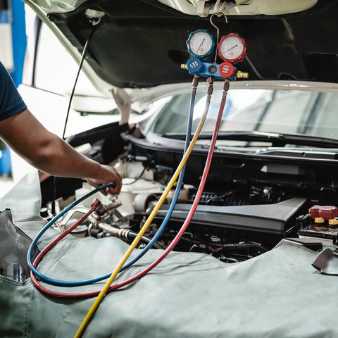 Pneumatic air tubing set with blue, yellow, and red hoses connected to a dual-gauge manifold under a car hood