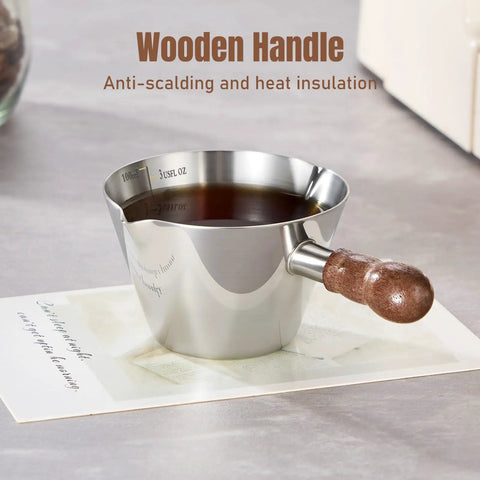 Close-up of espresso cup with wooden handle, part of 2 Piece Espresso Cup Set With Handle For Barista Level Pouring, 3.4 Oz Stainless Steel Cups
