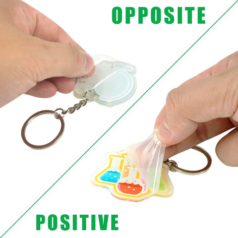 Hands holding Science Party Favors 12 Pack Keychains with Thank You Kraft Tags and Organza Bags, showing front and back view.