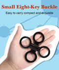 Hand holding 8 Pack Silicone Snorkel Keeper Clips for Mask Straps, small black buckle design with four circular loops for diving gear.