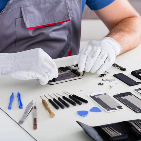 Technician using Badass Mini Phillips Screwdriver Set Four Millimeter Cross Heads for smartphone repair on a table.