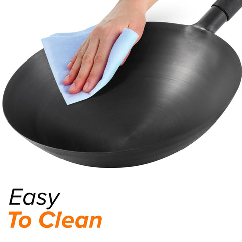 Hand wiping black surface of 14-inch carbon steel induction wok; Induction Wok That Lets You Dial In Temp From 100°F To 575°F In 5° Increments.