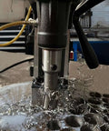 Close-up of S&F Stead & Fast magnetic drill press kit cutting into metal, with spiraled metal shavings around the bit.