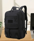 Black rugged hiking backpack for outdoor adventures and weekend trips, daypack travel pack on desk next to laptop