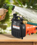 Portable 1600 GPH Water Transfer Pump With Half Horsepower on a table, garden background, attached to green hose