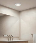 6.4 Inch Led Flush Mount Ceiling Light White Finish Delivers 1000 Lumens lighting a modern bathroom with mirror.