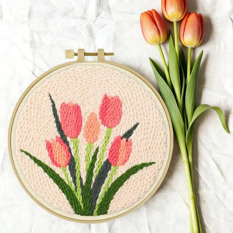 Punch Needle Embroidery Kit Beginner Friendly Two Pack With Tools Embroidery Hoops Two Pre Printed Fabrics And Color Threads Flower Pattern Set Tulip Bouquets And Sunflower Clusters DIY Home Decor Gift Project featuring tulip bouquet design in embroidery hoop with real tulips beside it