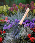 Mid Size Garden Fork For Loosening And Aerating Soil With Hardened Boron Steel Tines And Ash Hardwood Handle in flower bed