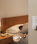 Bedroom setting with Smart Button Pusher For Rocker Switches And One Way Buttons, Bluetooth Control From Your Phone, No Wiring Needed.