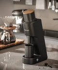 Heavy Duty Single Dose Coffee Grinder With Six Conical Burrs And Stepless Dial Delivers Hella Fine Ground Beans For Espresso Drip French Press Or Cold Brew Keeps Rock Solid Fresh on a modern kitchen counter.