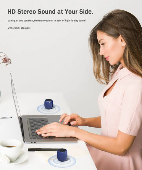 Woman using a laptop with Tiny But Mighty Bluetooth Speaker With 360 Degree HD Stereo Sound And Punchy Bass, Pocket Sized Yet Loud Mini Speaker on desk
