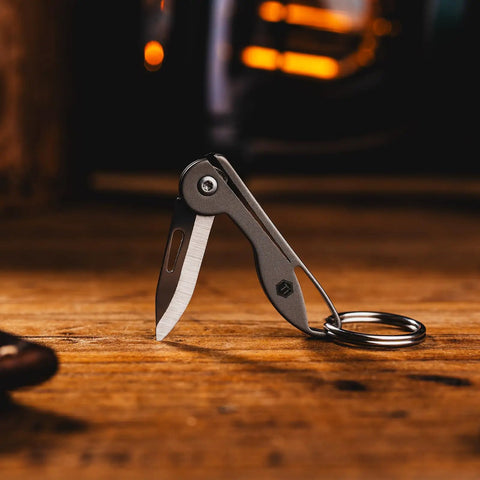Mini Titanium Pocket Knife For Everyday Carry With Razor Sharp Folding Blade on wooden surface