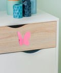 Front view of Butterfly Pink Cabinet Handles For Drawers And Cabinets, Vintage Style Furniture Hardware, Dresser Pulls Set, 1 Pair, Cute Pink Metal Knobs For Bedroom And Bathroom on wooden drawer