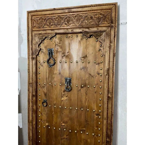 Natural Finish Hand Carved Barn Door In Rustic Solid Wood with ornate carvings and studs, 71x34in, custom size interior door