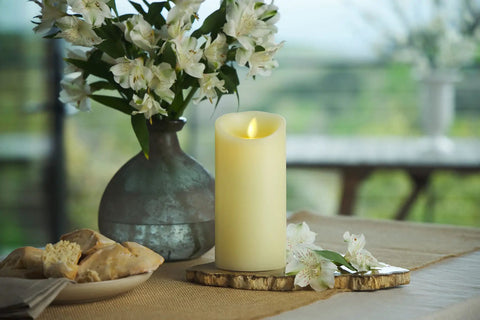 Cozy Flameless LED Candle With Moving Flame Pillar, Remote Ready And Timer, Battery Operated, on wood slice with flowers