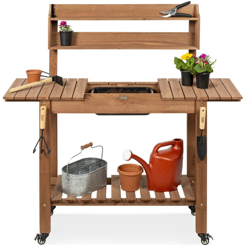 Mobile Garden Potting Bench With Sliding Tabletop Outdoor Wood Workstation with tools and plants on storage shelves, brown finish.
