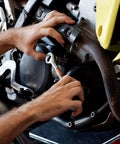 Hands using Essenti-Economy Motorcycle Tool Kit for Harley-Davidson and V-Twin Hybrids, Fits Most Fork Bags for repairs.