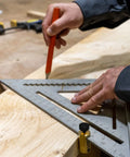 Carpenter using Beefy Brass Stair Gauge Set For Framing And Carpentry Squares with large knobs on a wood piece.