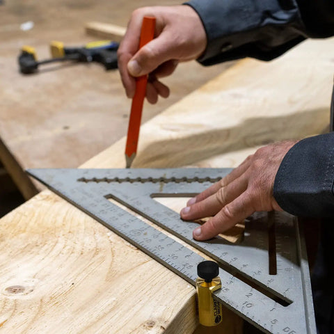 Carpenter using Beefy Brass Stair Gauge Set For Framing And Carpentry Squares with large knobs on a wood piece.