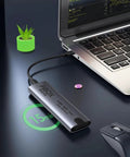 Hassle Free Nvme M2 Enclosure For Usb 3.2 Drives connected to a laptop on a desk with a plant nearby.