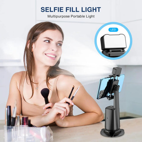 Face Tracking Tripod With 360 Degree Real Time Rotation For Smartphones, black, used with remote control for live streaming, on desk