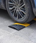 Heavy Duty Rubber Speed Bump 6 Foot Ramp With Integrated Cable Cover under car tire on concrete surface