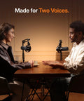Two people at a table using Hybrid Wireless Podcast Microphone With USB And XLR For PC Mac Phone Tablet, dynamic mic setup.