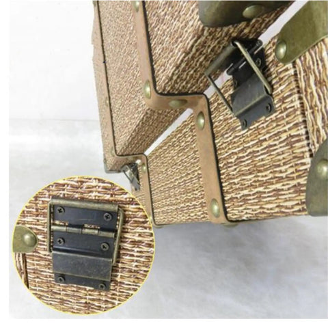 Close-up of Four Pack Antique Brass Door Hinge Set for Cabinets and DIY Projects on wicker box