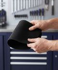 Hands holding a folded black carbon felt blanket from the 2 Pack Tough Fireproof Mat With High Heat Resistant Carbon Felt Blanket For Welding BBQ Pit And Grill Stove To Stop Sparks Safe Underlay.