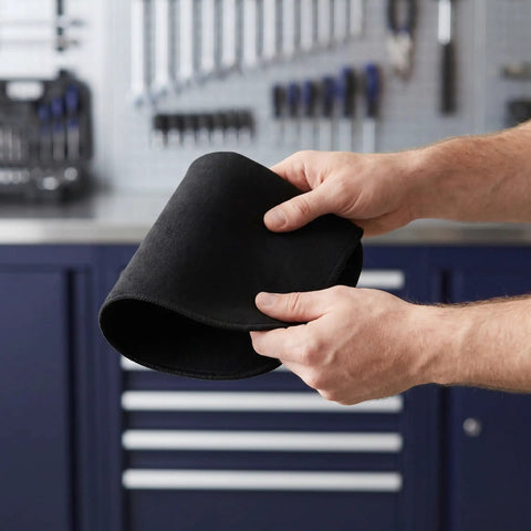 Hands holding a folded black carbon felt blanket from the 2 Pack Tough Fireproof Mat With High Heat Resistant Carbon Felt Blanket For Welding BBQ Pit And Grill Stove To Stop Sparks Safe Underlay.
