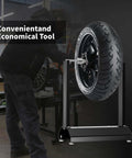 Beefy Motorcycle Wheel Balancer Stand For Static And Dynamic Tire Balancing On Most Motorcycles Off Road And Sport Bikes With A Chrome Plated Balance Bar And Rust Resistant Powder Coated Iron Construction in a garage setting