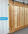 Wooden sliding door installed with wall mount brackets on a track system, shown in indoor setting with wooden panels.