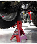 Jack Boss 2-ton jack stand under a car; red steel low-profile design.