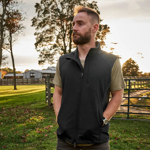 Men's Heavy Duty Softshell Vest With Smooth Four Way Stretch And Plush Fleece Lining designed for outdoor comfort in a scenic setting.