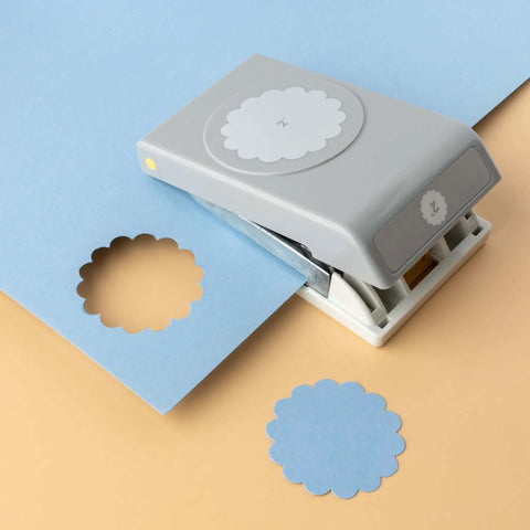 2 Inch Scallop Circle Paper Punch For Scrapbooks And Card Making, gray metal craft punch with lockable stackable design on blue paper