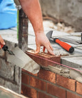 Building wall with Three Piece Masonry Tools Set Featuring Seven Inch Gauging Trowel, Six Inch Margin Trowel, Five And A Half Inch Pointing Trowel