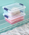 Four Pack 15 Quart Storage Bins With Hella Sturdy Snap Tops And Crystal Clear Lids Stackable Plastic Totes storing clothes and a hat on a shelf.