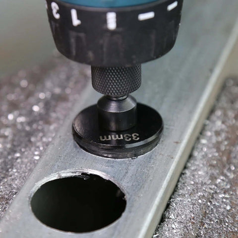 Close-up of a black 33mm hole saw arbor mounted in a drill chuck.