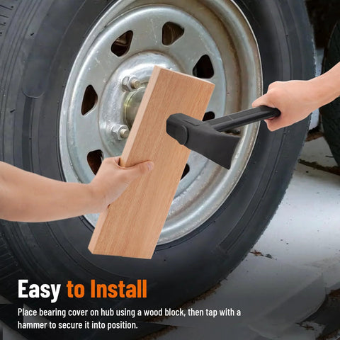 Trailer wheel bearing protector kit, 1.98-inch, being installed on a trailer hub with a wooden block and hammer.