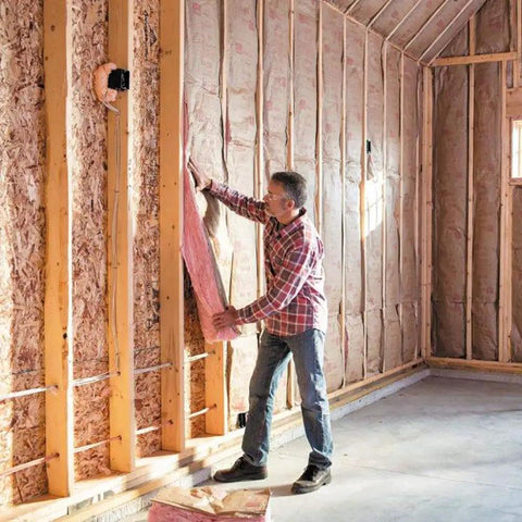 Pro Grade R13 Kraft Fiberglass Roll Insulation for 2x4 walls being installed between studs in a home under construction.
