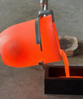 Heavy Duty Graphite Crucible With Smooth Pouring Spout For Melting Aluminum Up To 1800 C pouring molten metal into a black mold.