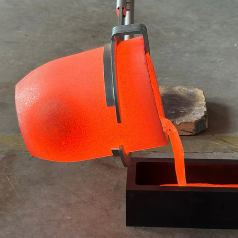 Heavy Duty Graphite Crucible With Smooth Pouring Spout For Melting Aluminum Up To 1800 C pouring molten metal into a black mold.
